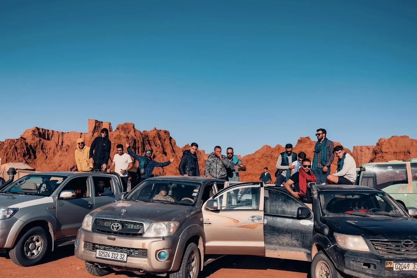 Tourago travellers on their 4x4s among the red rock of the Tadrart, near Djanet