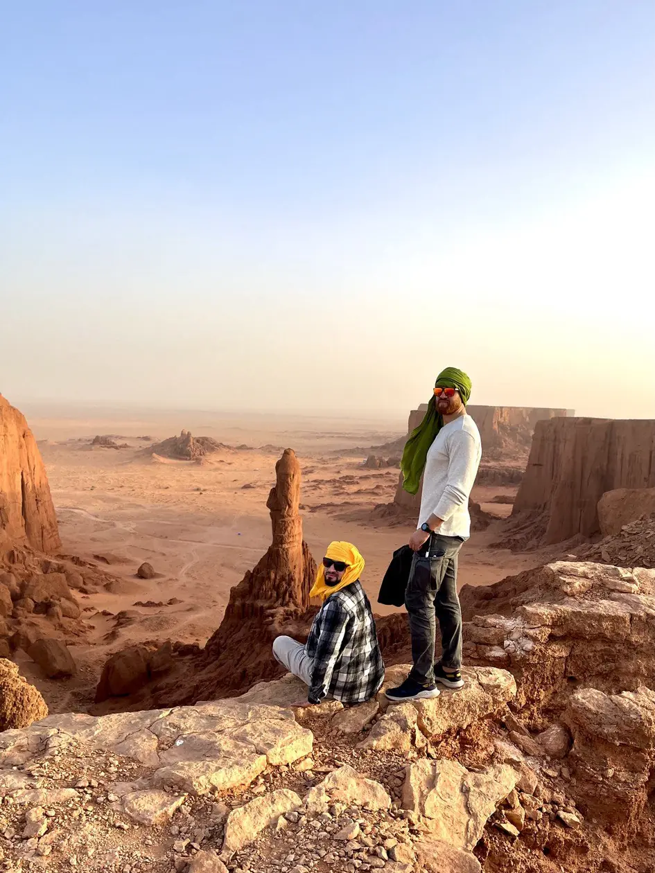 Two travellers on a rock above the canyon at Brezina