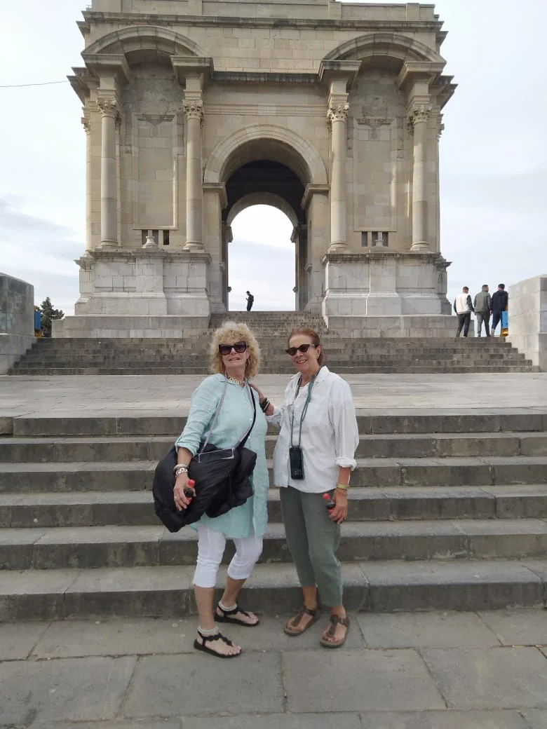 Two travellers on the steps of the war memorial at Constantine