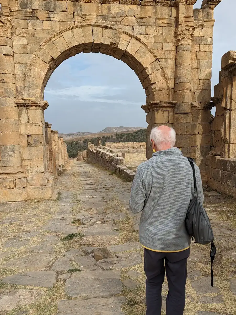 A traveller walking through the Arch of Caracalla at Djemila
