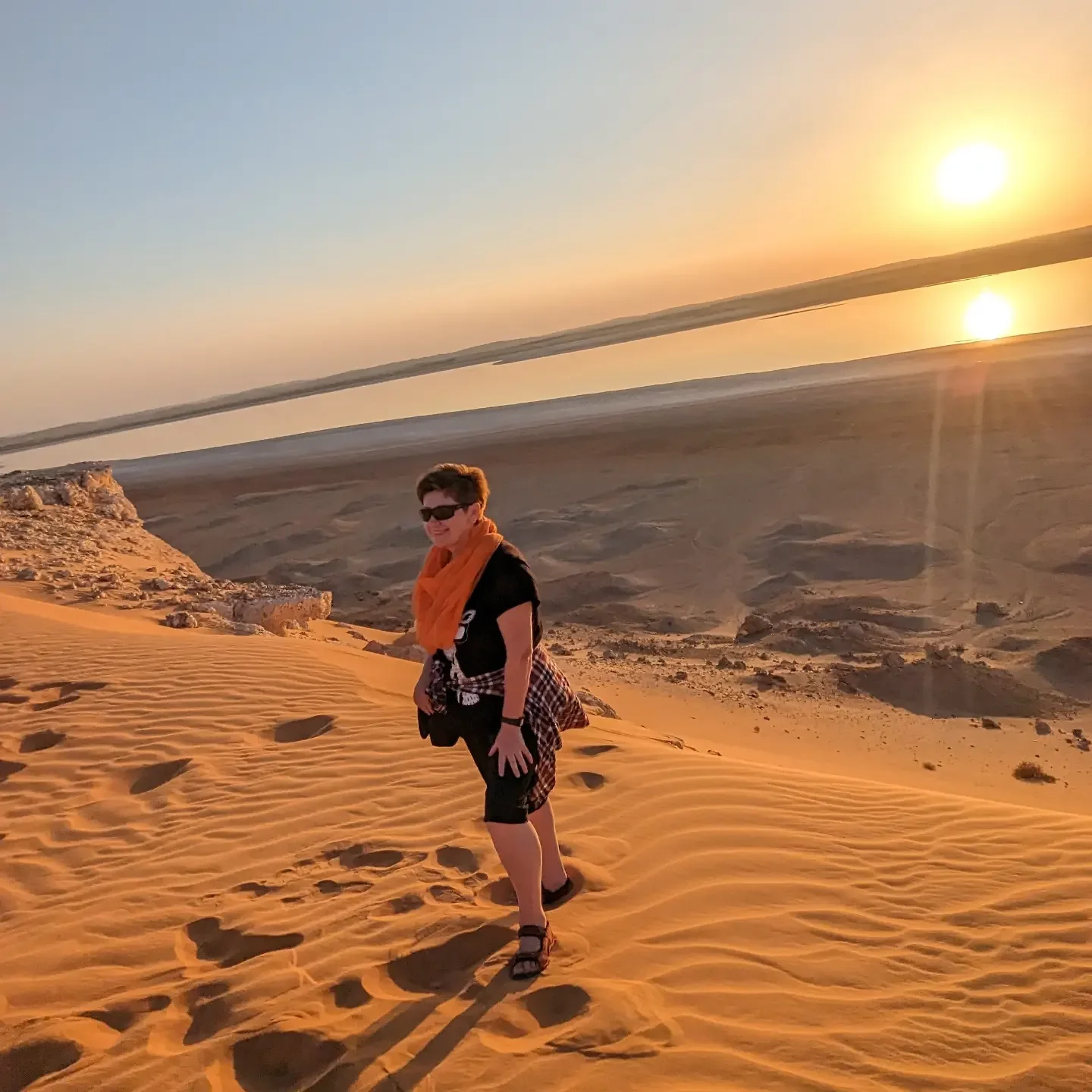 A traveller standing on a dune at El Menia as the sun goes down