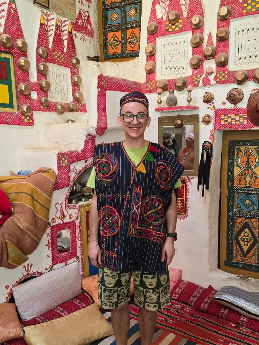 A host in a craft workshop hung with rugs and copper in Ghardaïa