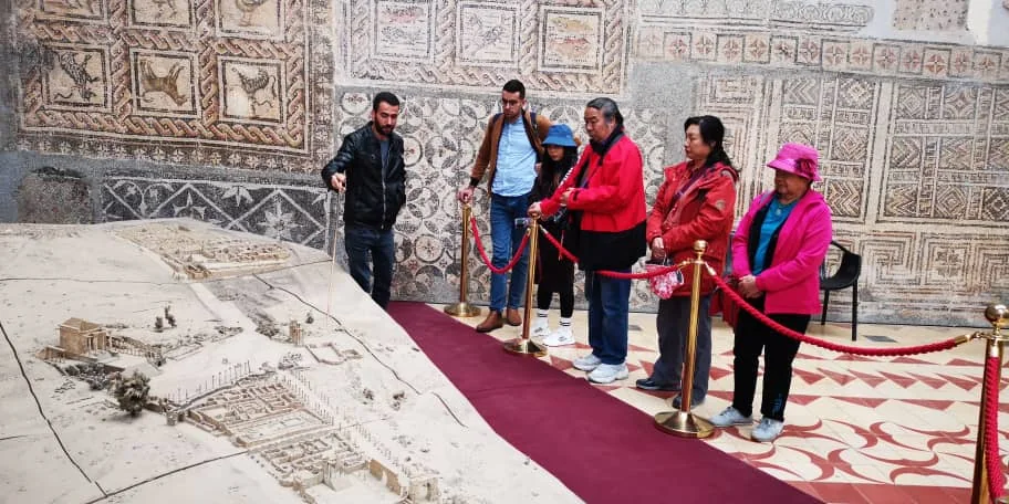 Tourago travellers in front of the Roman mosaics of the Djemila museum