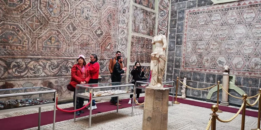 Travellers in the Cuicul museum at Djemila, among wall-mounted Roman mosaics
