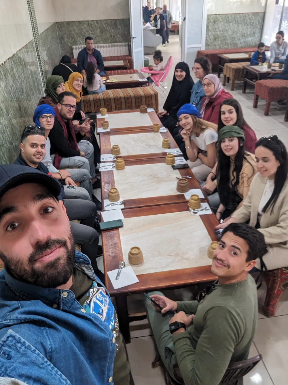 Tourago travellers around a long table in a tea room at Bou Saada